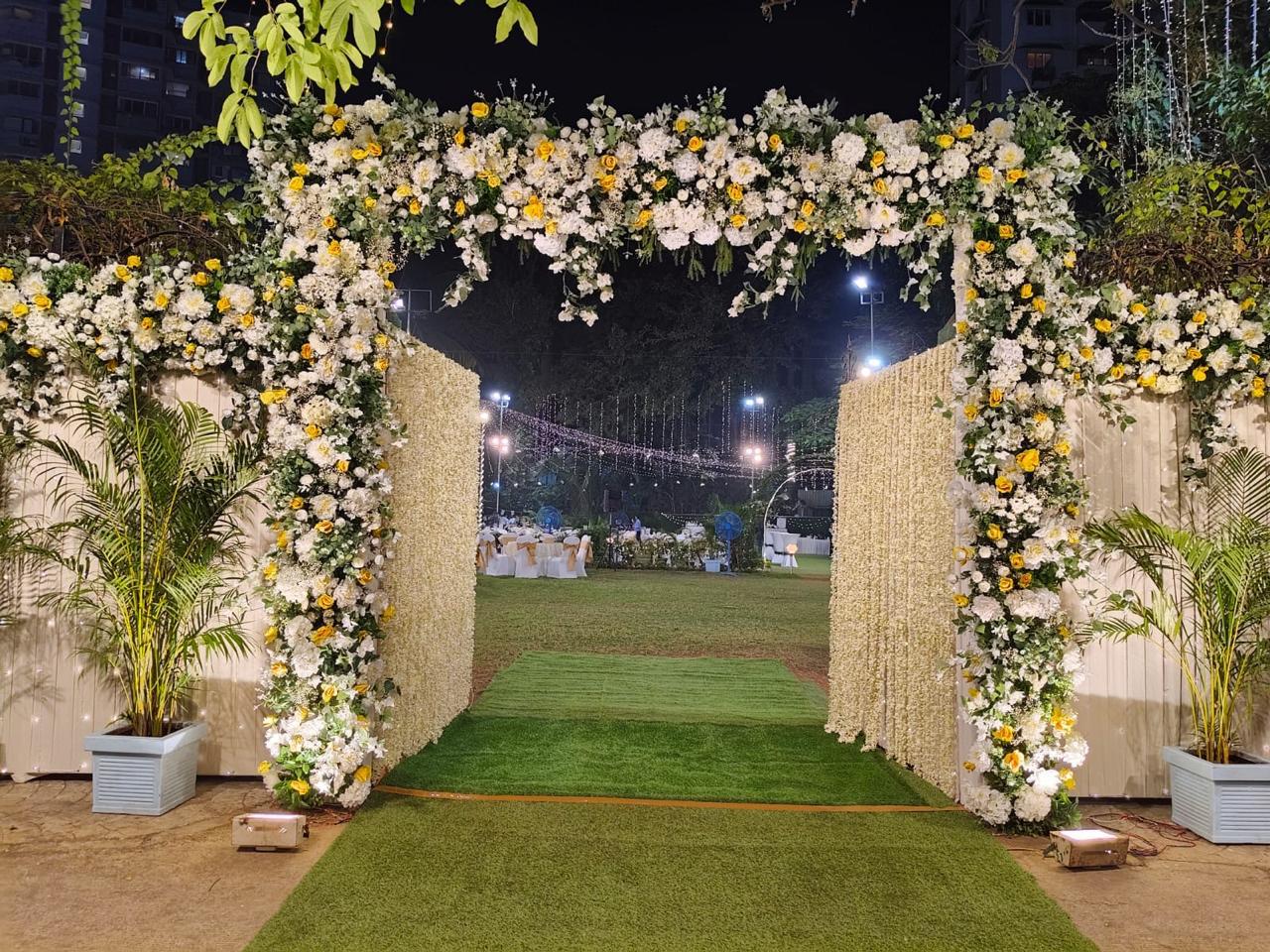 Daytime lush garden entrance arch with white floral blooms
