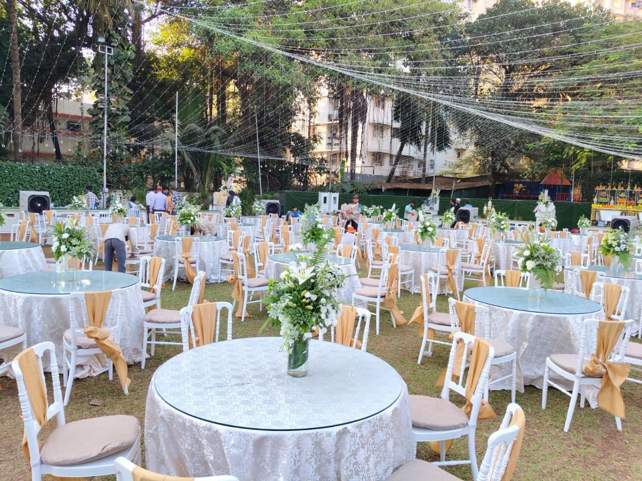 Spacious outdoor wedding lawn in Colaba with lush greenery, fairy lights and banquet seating